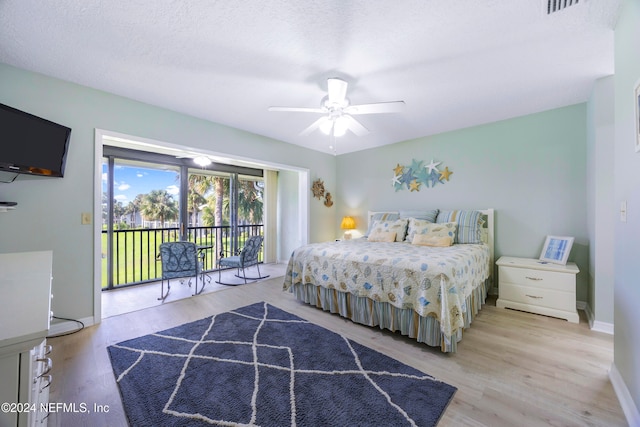 bedroom featuring access to exterior, ceiling fan, light hardwood / wood-style floors, and a textured ceiling