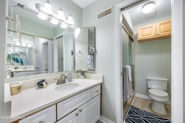 bathroom featuring hardwood / wood-style floors, vanity, toilet, and an enclosed shower