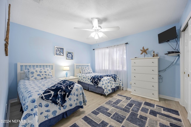 bedroom with wood-type flooring, a closet, and ceiling fan