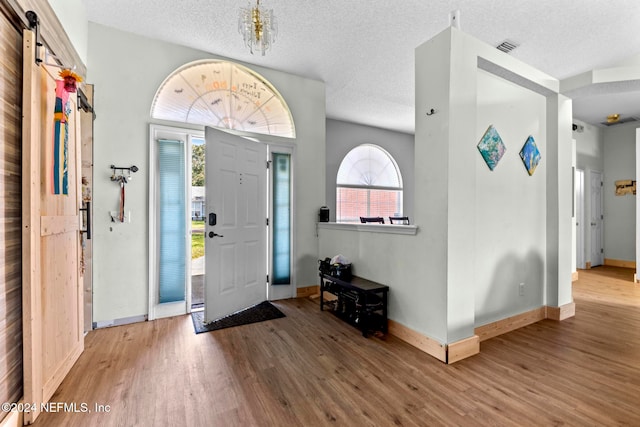 entryway with hardwood / wood-style floors, a barn door, and a textured ceiling