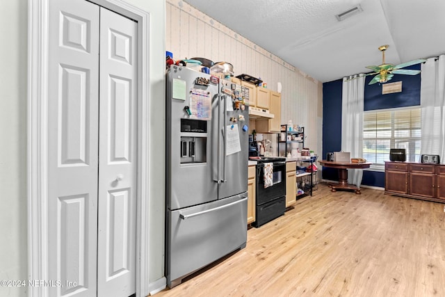 kitchen with black electric range oven, stainless steel fridge, light brown cabinets, ceiling fan, and light hardwood / wood-style flooring