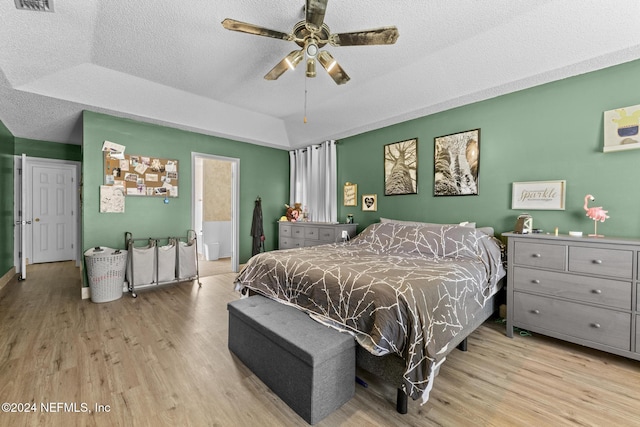 978 Tammy Cove Ln, Jacksonville, FL 32218 - bedroom featuring wood finished floors, ensuite bathroom, ceiling fan, a raised ceiling, and a textured ceiling