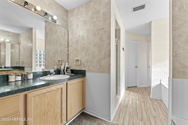978 Tammy Cove Ln, Jacksonville, FL 32218 - full bathroom featuring wood finished floors, a stall shower, a textured ceiling, and visible vents