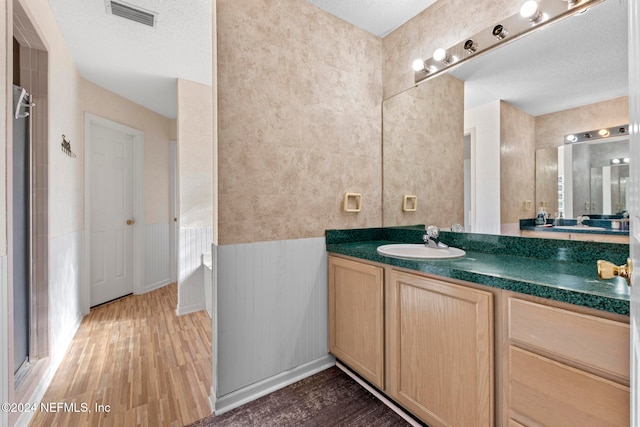 bathroom featuring vanity, a textured ceiling, and wood-type flooring