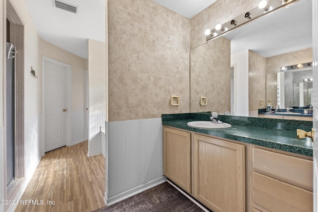 978 Tammy Cove Ln, Jacksonville, FL 32218 - full bath with visible vents, vanity, wood finished floors, walk in shower, and a wainscoted wall