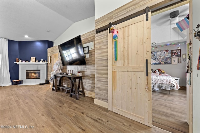 978 Tammy Cove Ln, Jacksonville, FL 32218 - living room with a barn door, wood finished floors, lofted ceiling, and a tile fireplace