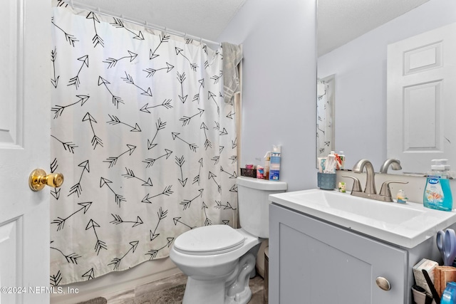 full bathroom with vanity, a textured ceiling, shower / bath combo with shower curtain, and toilet