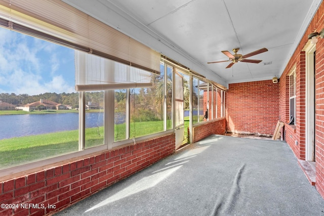 unfurnished sunroom featuring a water view and ceiling fan