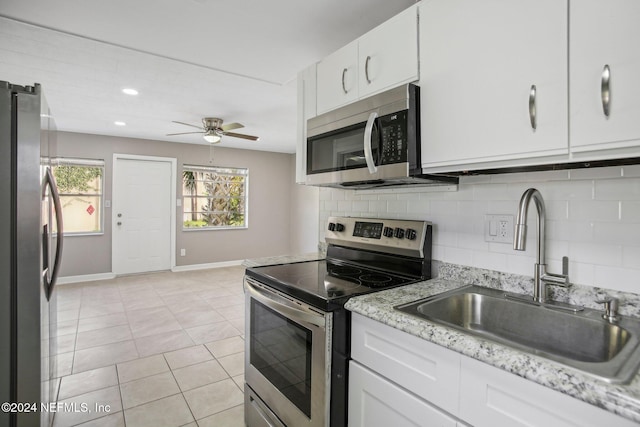 3730 Abby Ln, Jacksonville, FL 32207 - kitchen featuring white cabinetry, sink, decorative backsplash, light tile patterned flooring, and appliances with stainless steel finishes