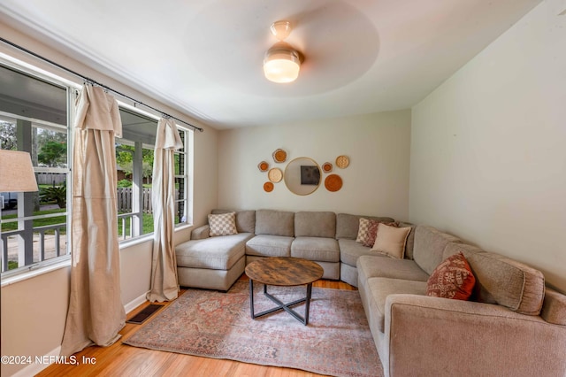 living room featuring wood-type flooring and ceiling fan