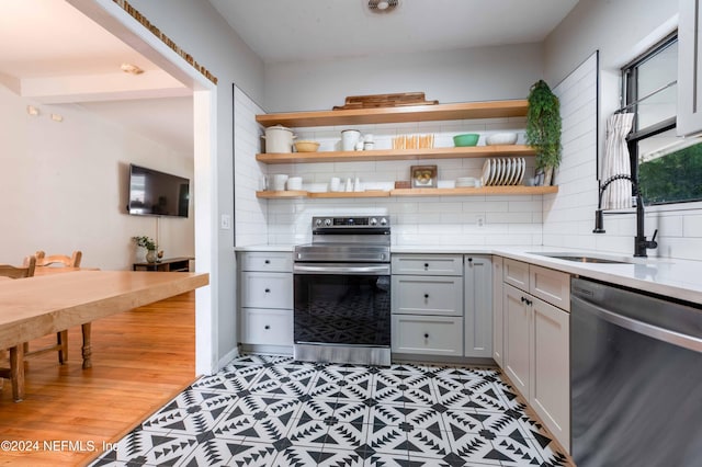 kitchen featuring gray cabinetry, backsplash, and stainless steel appliances