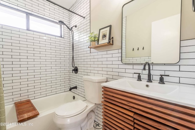 full bathroom featuring backsplash, toilet, tile walls, vanity, and tiled shower / bath combo