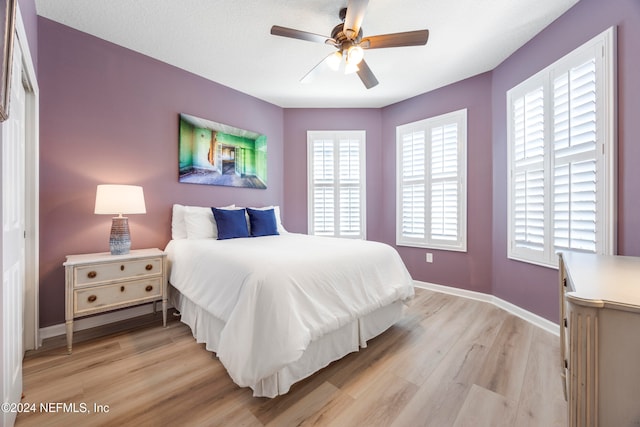 bedroom with light hardwood / wood-style flooring, multiple windows, a closet, and ceiling fan