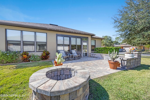 rear view of property with a patio area, a lawn, and a fire pit