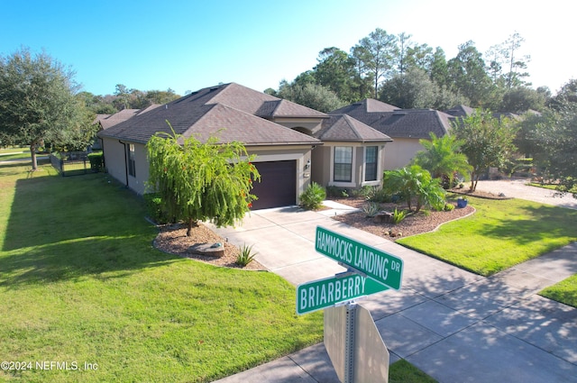 view of front of property featuring a front yard and a garage