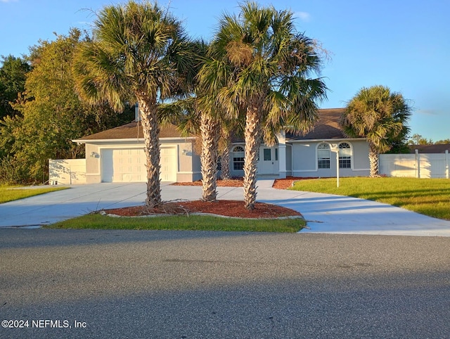 ranch-style home featuring a garage and a front lawn