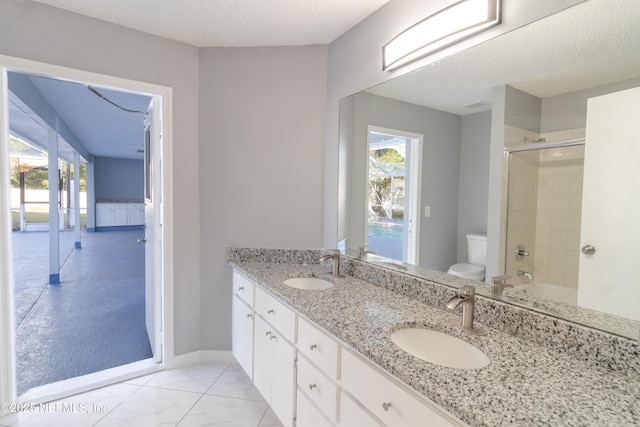 bathroom with vanity, tile patterned floors, a textured ceiling, and toilet