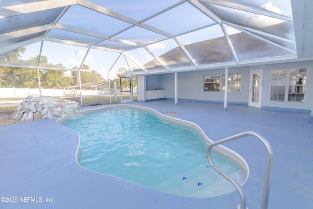 view of swimming pool featuring pool water feature, a patio, and a lanai