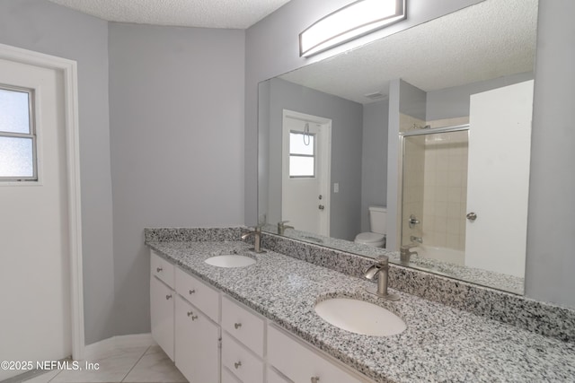 bathroom with vanity, toilet, and a textured ceiling