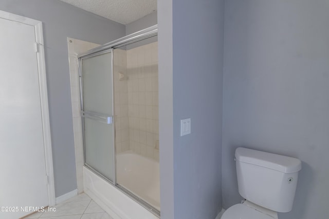 bathroom with tile patterned floors, enclosed tub / shower combo, a textured ceiling, and toilet