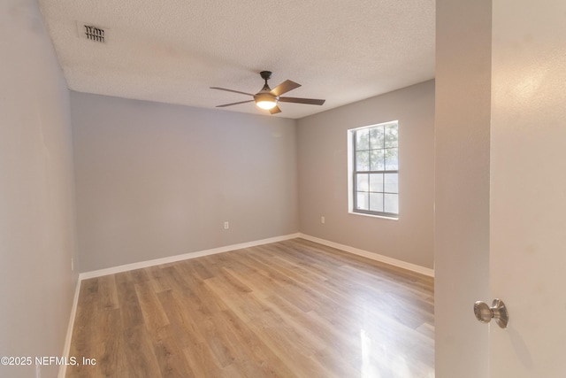 spare room with light wood-type flooring, a textured ceiling, and ceiling fan