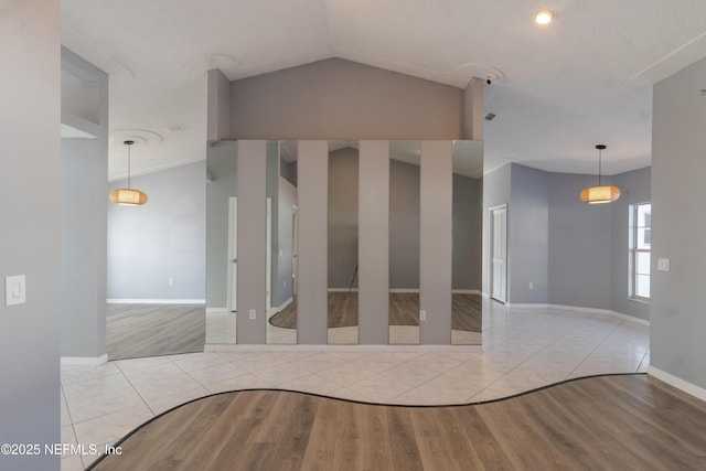 interior space with light wood-type flooring and vaulted ceiling