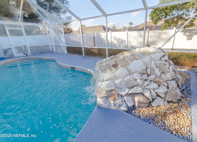 view of pool featuring pool water feature and glass enclosure