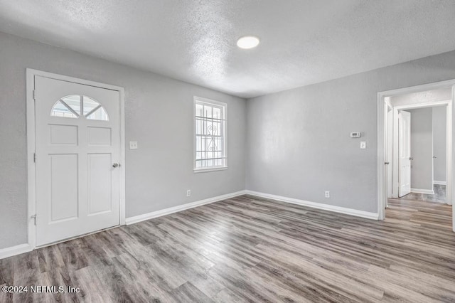 entryway with hardwood / wood-style floors and a textured ceiling