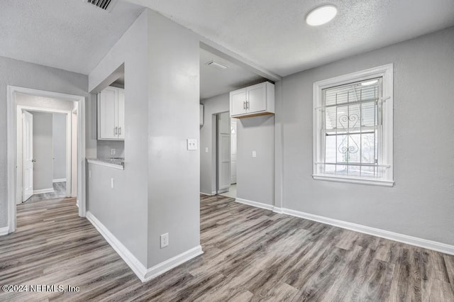 kitchen featuring white cabinets, a textured ceiling, and light hardwood / wood-style floors