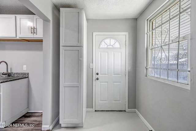 entryway with sink and a textured ceiling