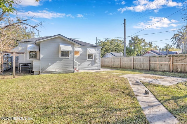 rear view of property with a lawn