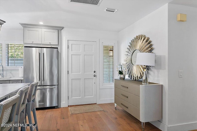 kitchen with light hardwood / wood-style floors, sink, and high end fridge