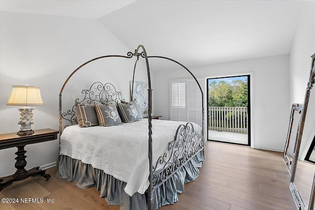 bedroom featuring access to exterior, hardwood / wood-style flooring, and vaulted ceiling