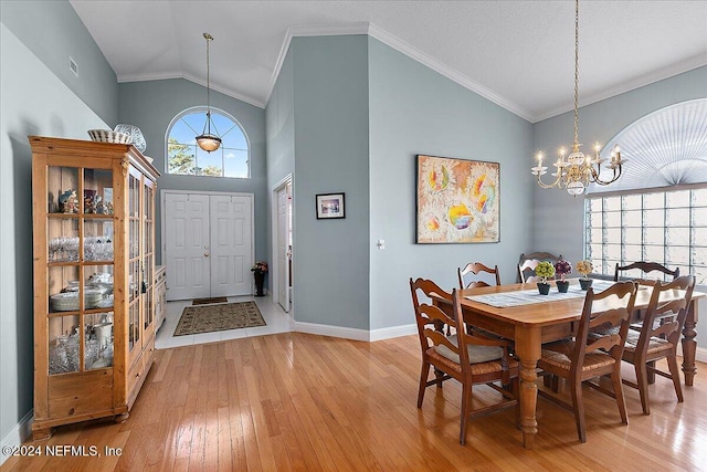 dining space with crown molding, high vaulted ceiling, an inviting chandelier, and hardwood / wood-style flooring