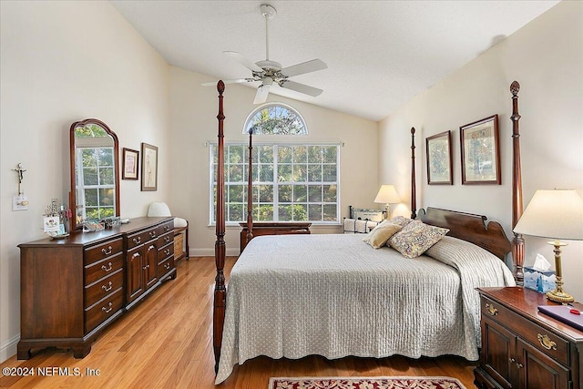 bedroom featuring ceiling fan, vaulted ceiling, light wood-type flooring, and a textured ceiling