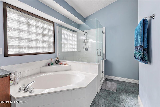 bathroom featuring separate shower and tub and a textured ceiling