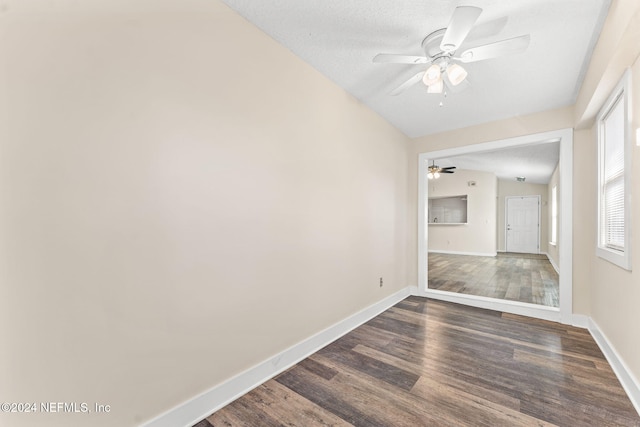 spare room featuring dark hardwood / wood-style floors, a textured ceiling, vaulted ceiling, and ceiling fan