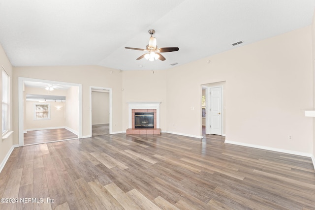 unfurnished living room featuring hardwood / wood-style flooring, ceiling fan, a fireplace, and vaulted ceiling