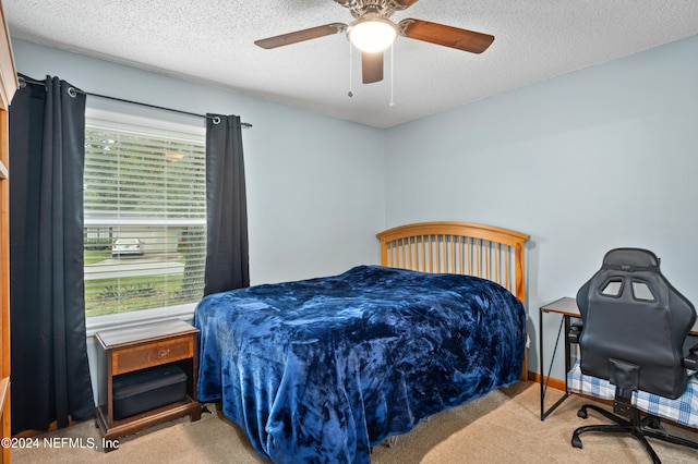 carpeted bedroom with ceiling fan and a textured ceiling