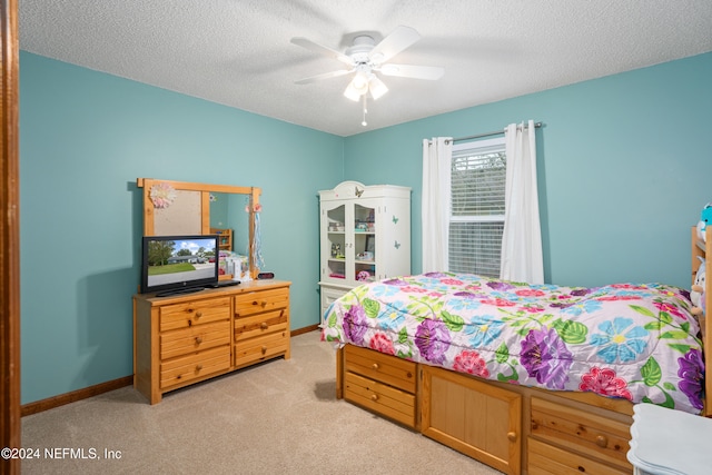 carpeted bedroom featuring a textured ceiling and ceiling fan