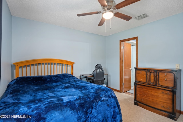 carpeted bedroom with a textured ceiling and ceiling fan