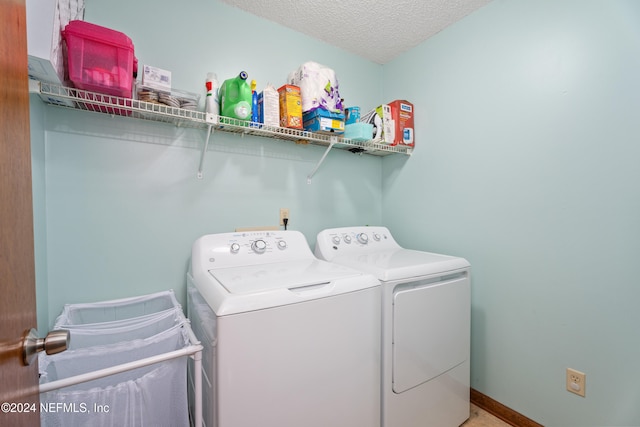 clothes washing area with a textured ceiling and separate washer and dryer