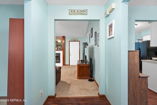 corridor featuring a textured ceiling and carpet floors