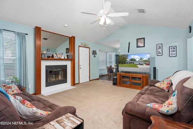 living room with lofted ceiling, a fireplace, light colored carpet, a textured ceiling, and ceiling fan