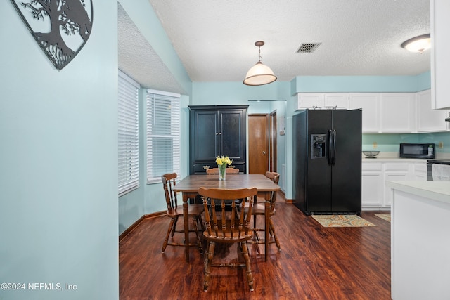 dining area featuring dark hardwood / wood-style floors and a textured ceiling