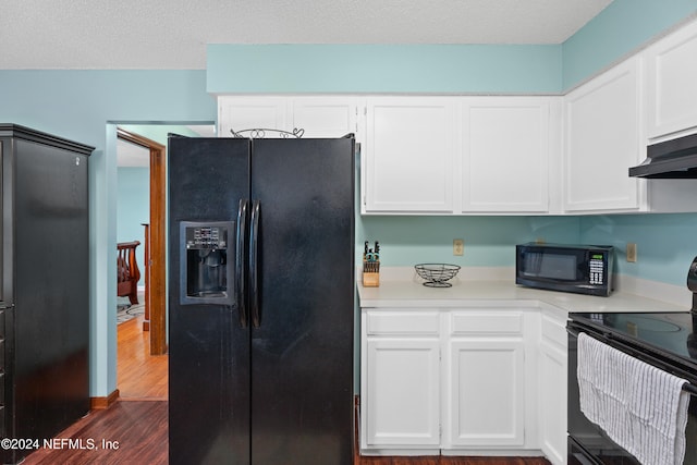 kitchen with dark wood-type flooring, a textured ceiling, black appliances, and white cabinetry