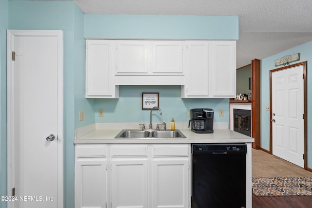 kitchen featuring black dishwasher, white cabinetry, a textured ceiling, dark wood-type flooring, and sink