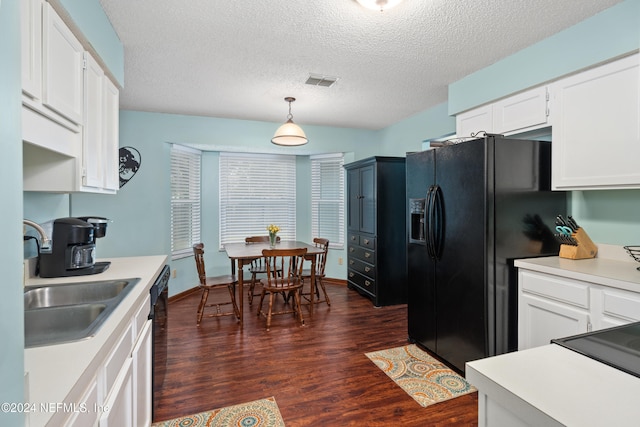 kitchen featuring white cabinets, a textured ceiling, black appliances, dark wood-type flooring, and decorative light fixtures