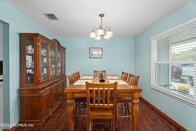 dining room with a textured ceiling, a notable chandelier, dark hardwood / wood-style floors, and plenty of natural light