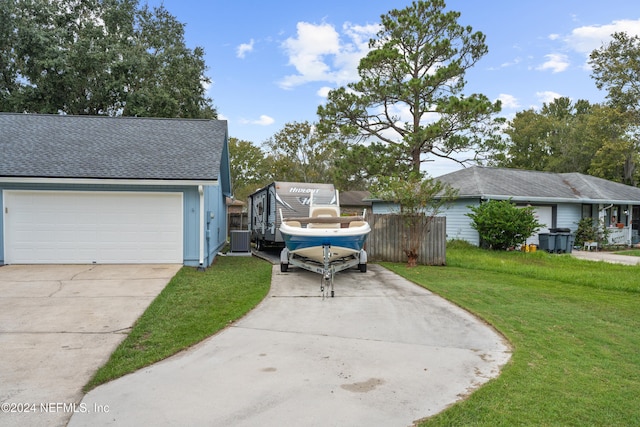 view of front of property featuring a front yard, a garage, and central AC unit